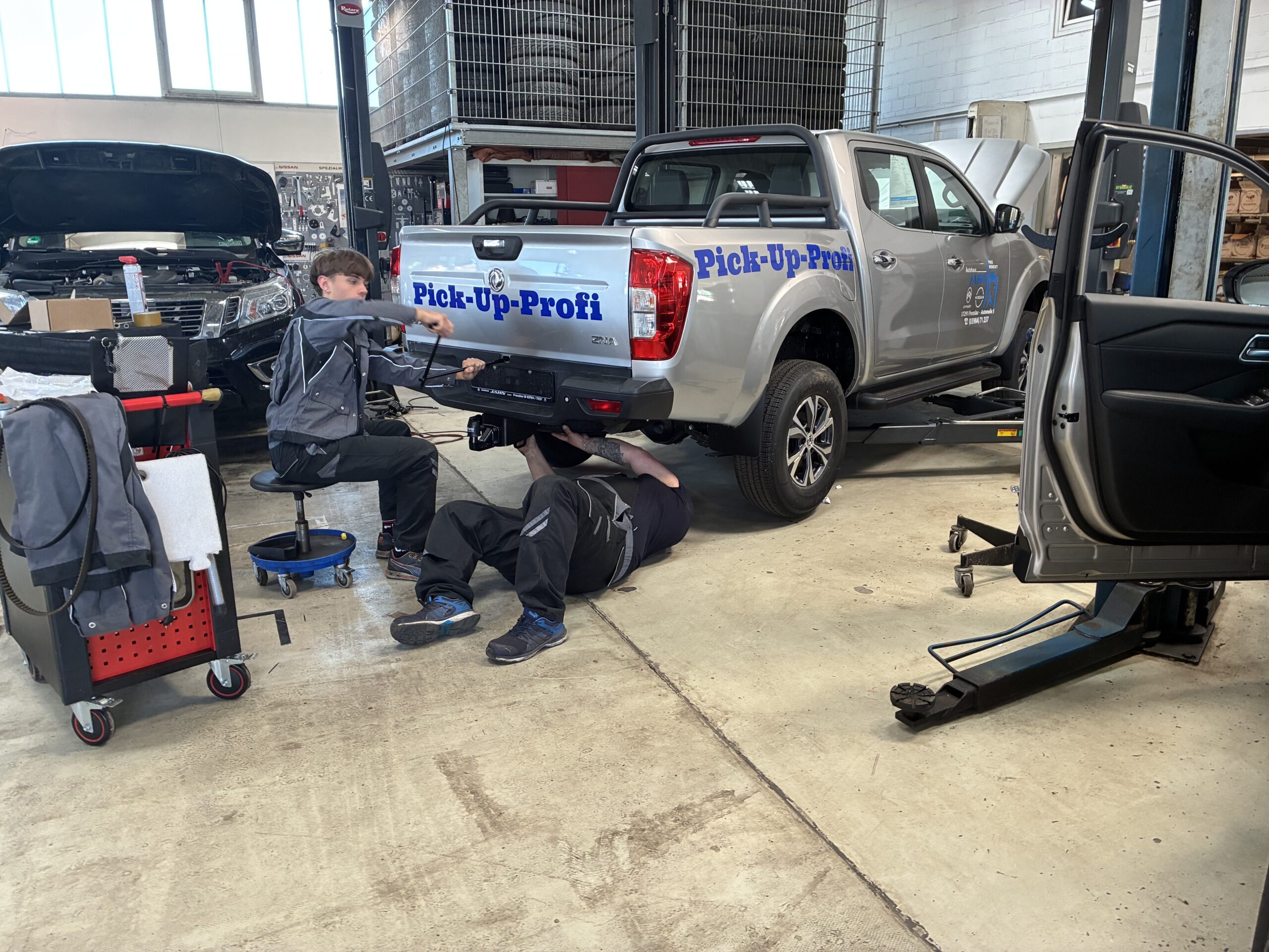 Pick-up mit Pick-Up-Profi-Beschriftung auf der Hebebühne in der Werkstatt des Autohaus Jahn